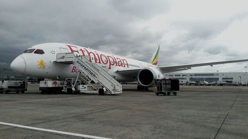 Airplane on airport runway against sky