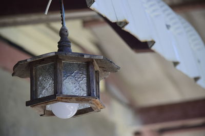 Low angle view of lantern hanging in old building