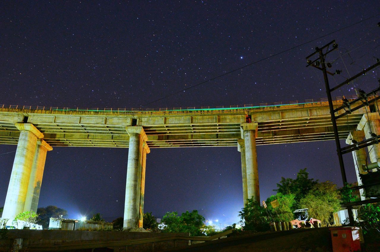night, connection, low angle view, bridge - man made structure, architecture, built structure, outdoors, star - space, no people, sky, nature, illuminated, tree, astronomy, clear sky