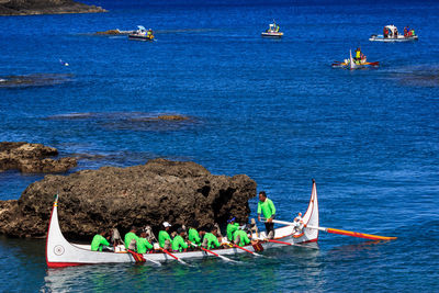 People in boat on sea against blue sky