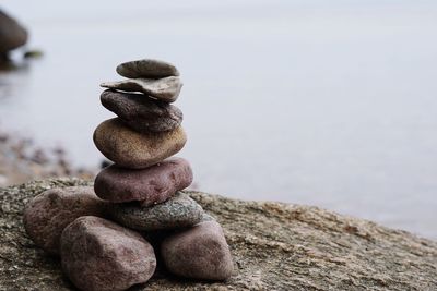 Stack of stones on beach against sky