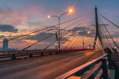 Illuminated rama viii bridge against cloudy sky at dusk in city