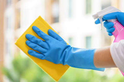 Cropped hands of person cleaning window