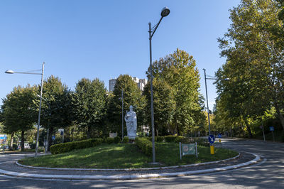 View of street amidst trees against clear sky