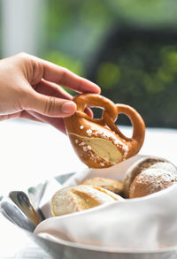 Cropped hand of person holding donuts