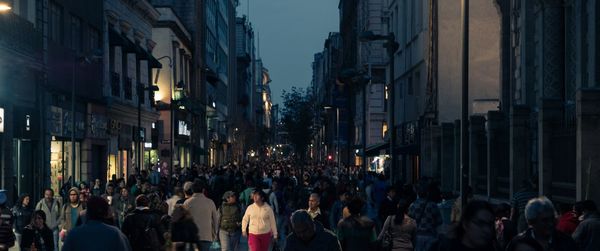 Crowd on street amidst buildings at night