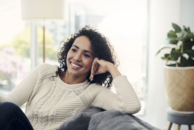 Portrait of smiling young woman sitting at home