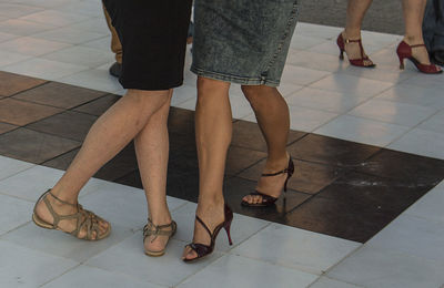 Low section of people dancing on tiled floor