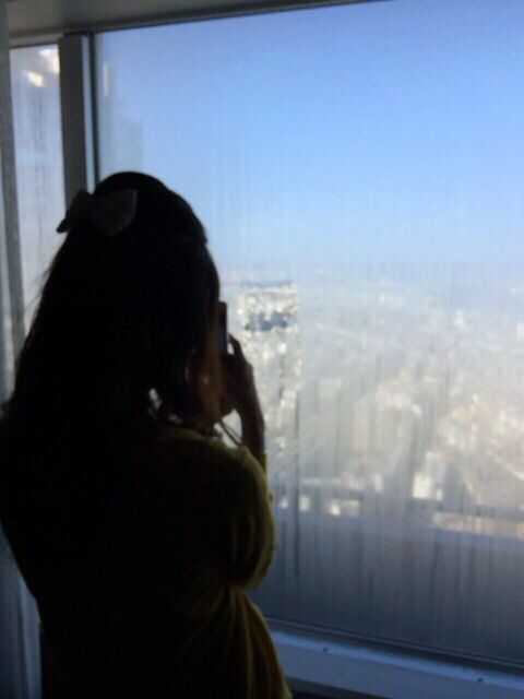 indoors, headshot, lifestyles, window, head and shoulders, young adult, looking through window, leisure activity, glass - material, person, young women, transparent, rear view, side view, waist up, contemplation, looking away, clear sky