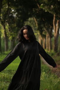 Low angle view of woman standing against trees
