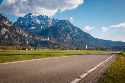 Road by mountains against sky