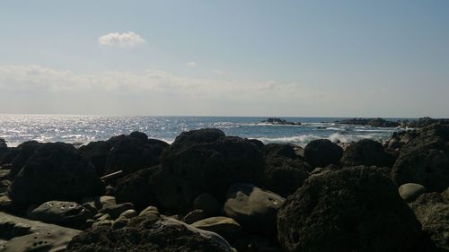 Rocks on beach against sky