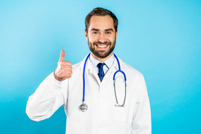 Portrait of smiling young man against blue background