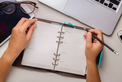 Midsection of woman holding paper with text on table