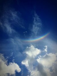 Low angle view of rainbow against cloudy sky