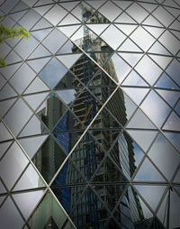 Low angle view of modern steel and glass building against sky