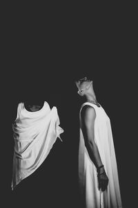 Rear view of women standing against black background