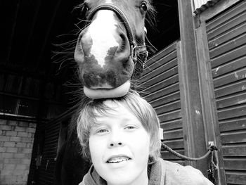 Portrait of boy with horse at stable