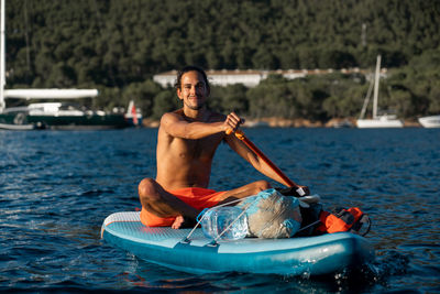 Portrait of shirtless man in boat