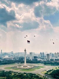 Birds flying over buildings in city