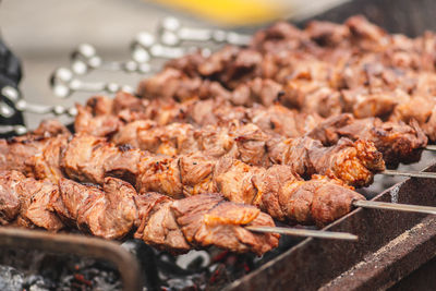 Pork meat skewer, grilled or roasted in a barbecue on an open fire and flames, shashlik or shashlyk