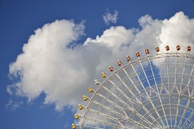 Low angle view of ferris wheel against cloudy sky