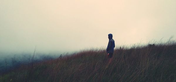 Man standing on field against sky