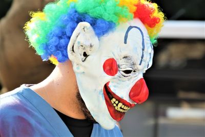 Close-up of man wearing clown mask