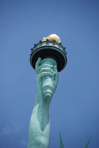 Low angle view of statue against blue sky