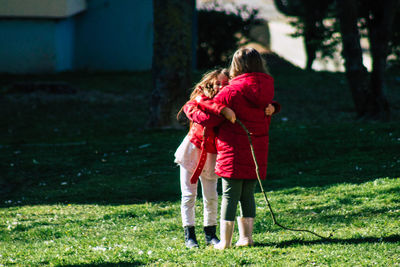 Rear view of mother and daughter on grass