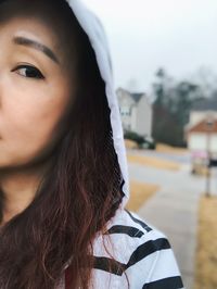 Close-up portrait of young woman in hood clothing