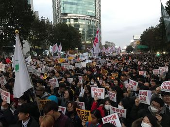 Crowd in city against sky