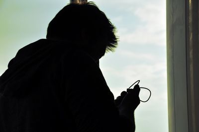 Close-up of silhouette man against cloudy sky