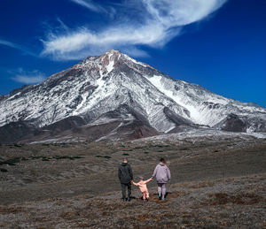 People on snowcapped mountain against sky