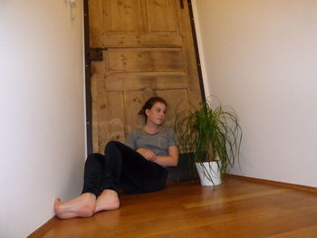 Young woman sitting on sofa at home