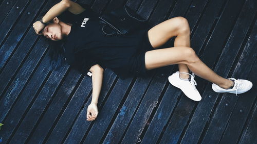 High angle view of woman lying down on boardwalk