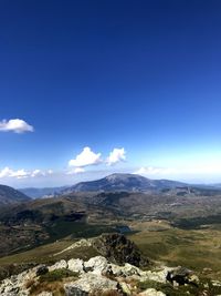 Scenic view of mountains against blue sky