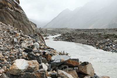 Scenic view of river by mountains against sky