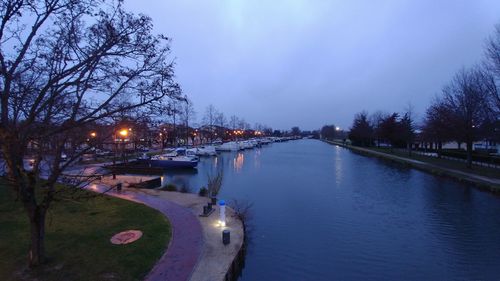 River amidst illuminated city against sky at night