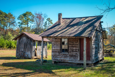 Exterior of abandoned house on field against sky