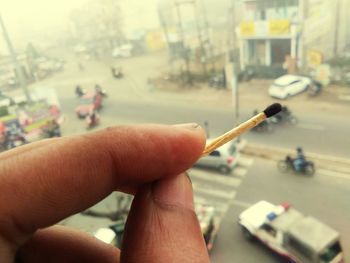 Close-up of man holding cigarette