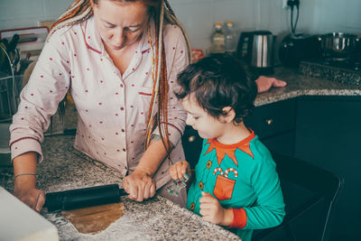 Holiday magic comes alive in the kitchen as a cheerful mom and her son prepare christmas gingerbread