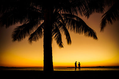 Silhouette people at beach during sunset