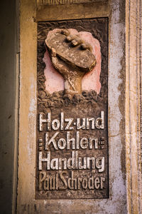 Close-up of rusty sign on wall