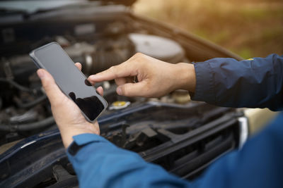 Midsection of man using mobile phone