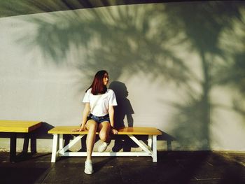 Portrait of young woman sitting on bench