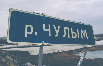 Close-up of information sign against sky