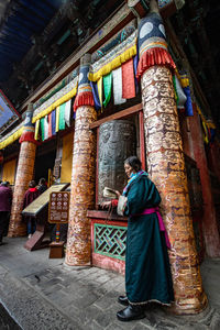 Full length rear view of men standing outside building