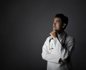 Thoughtful doctor over black background