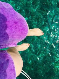 Low section of woman with purple legs in water